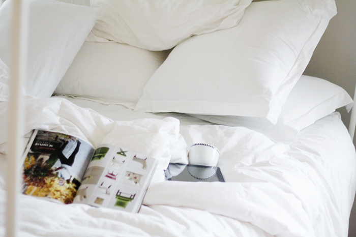 big fluffy white bed coffee and magazines