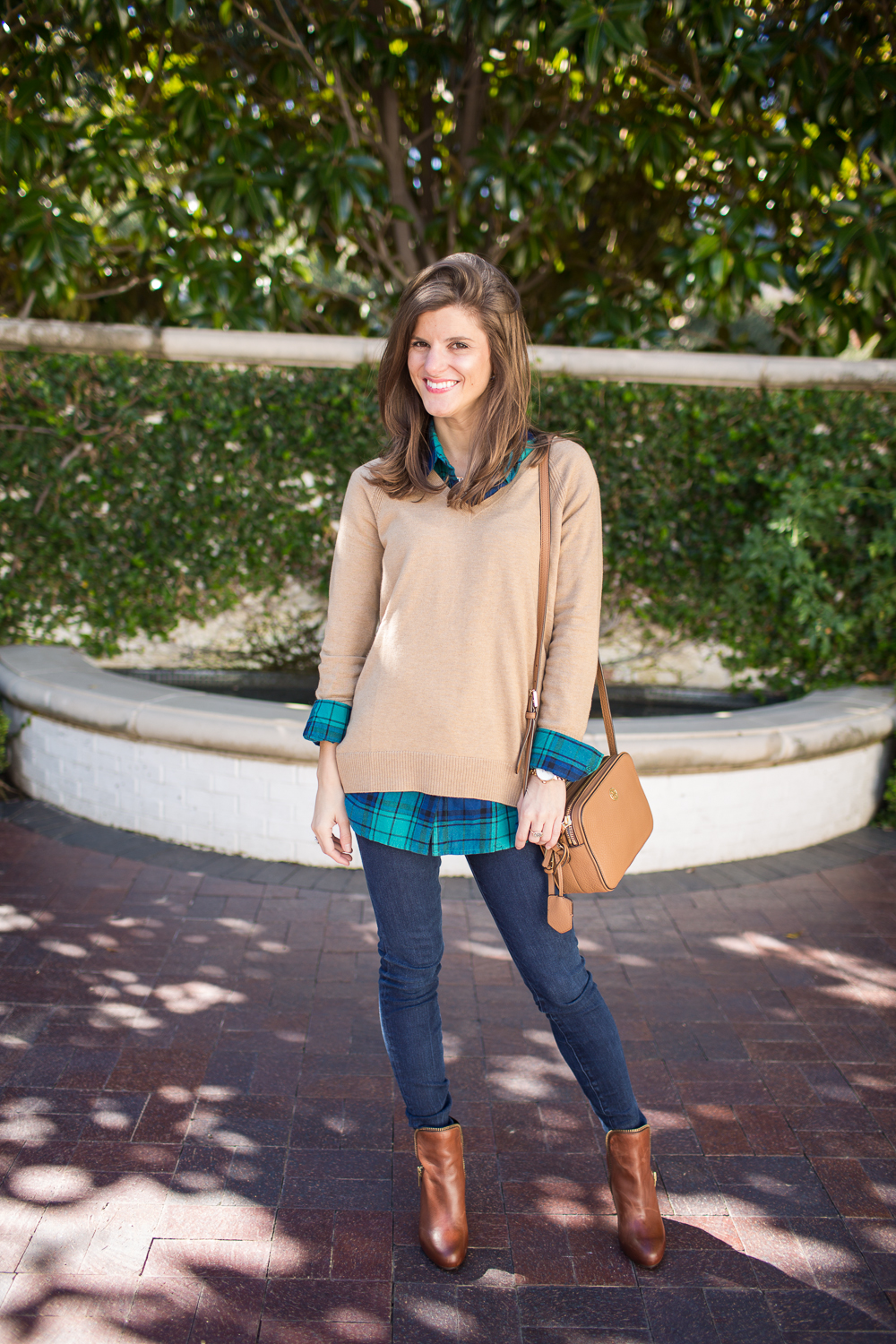 tan sweater over green and blue plaid shirt