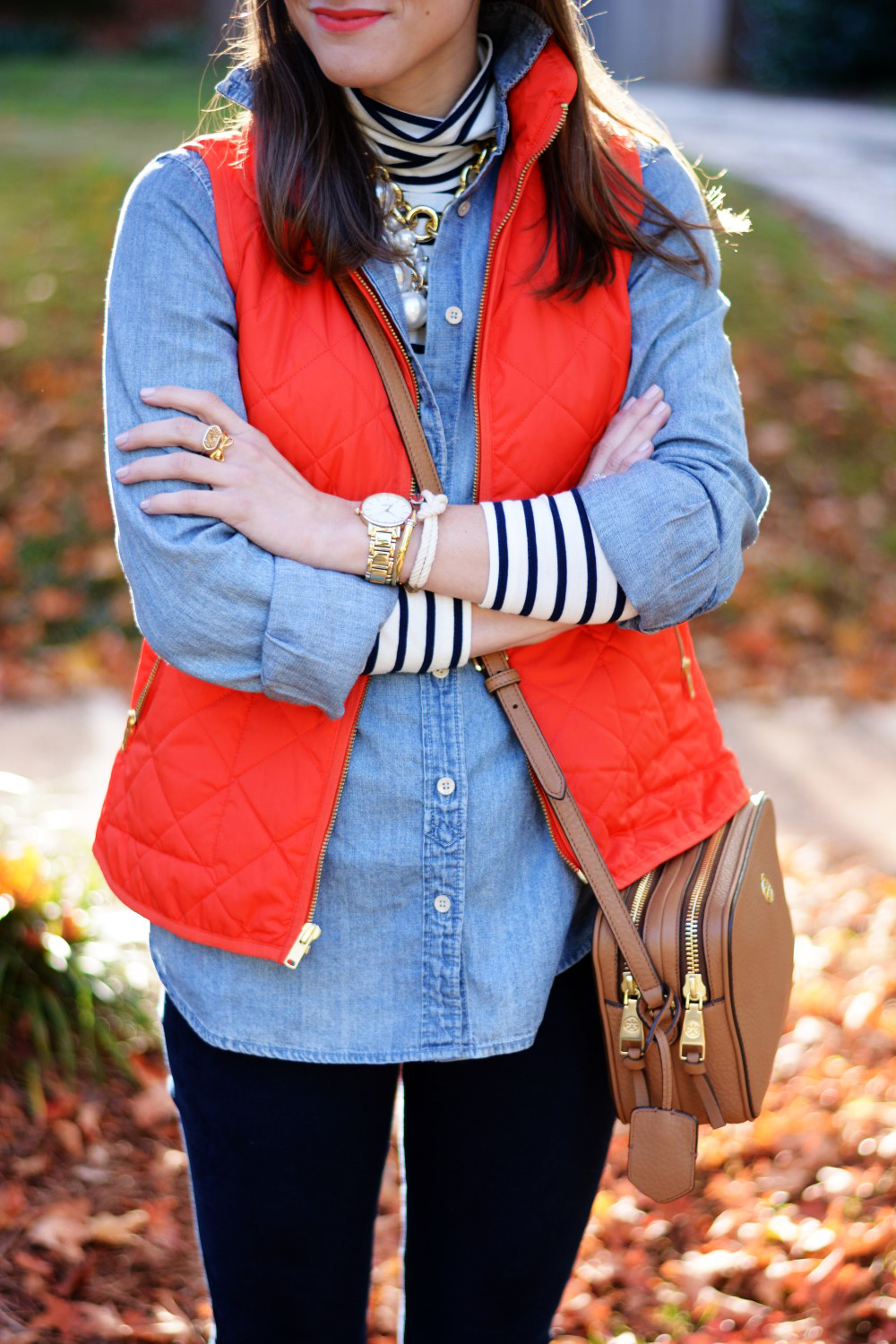 chambray shirt over striped turtleneck with puffer vest