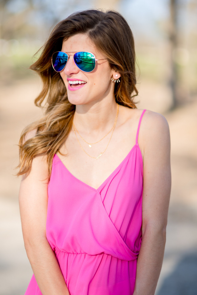 brightontheday wearing hot pink criss cross tank with layered delicate necklaces and white jeans