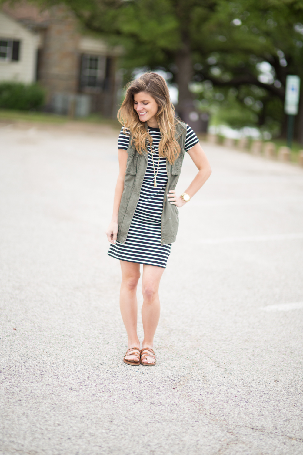 striped dress, utility vest, strappy brown leather sandals, casual everyday outfit, transitional style, outfit with utility vest, stripes and military vest, outfit with flats, casual outfit idea, how to wear a utility vest, gold pendant necklace