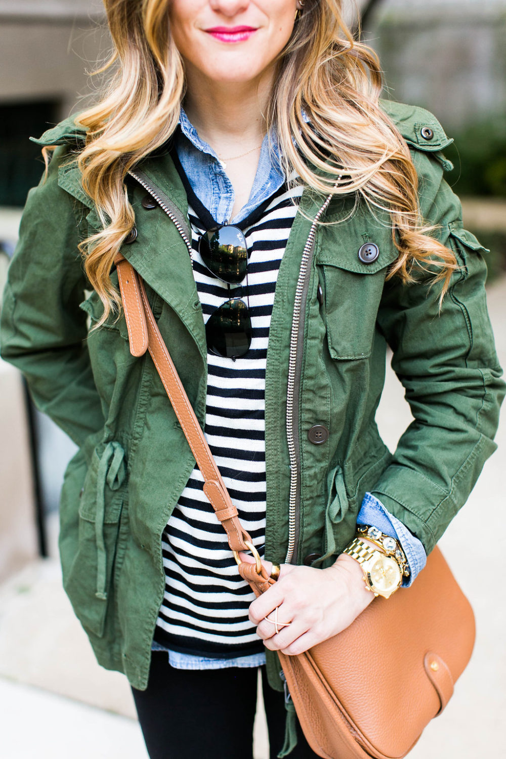 military jacket layered over black and white stripes and chambray shirt