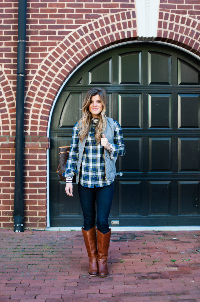 preppy outfit with striped turtleneck and plaid button up and grey puffer vest and frye riding boots