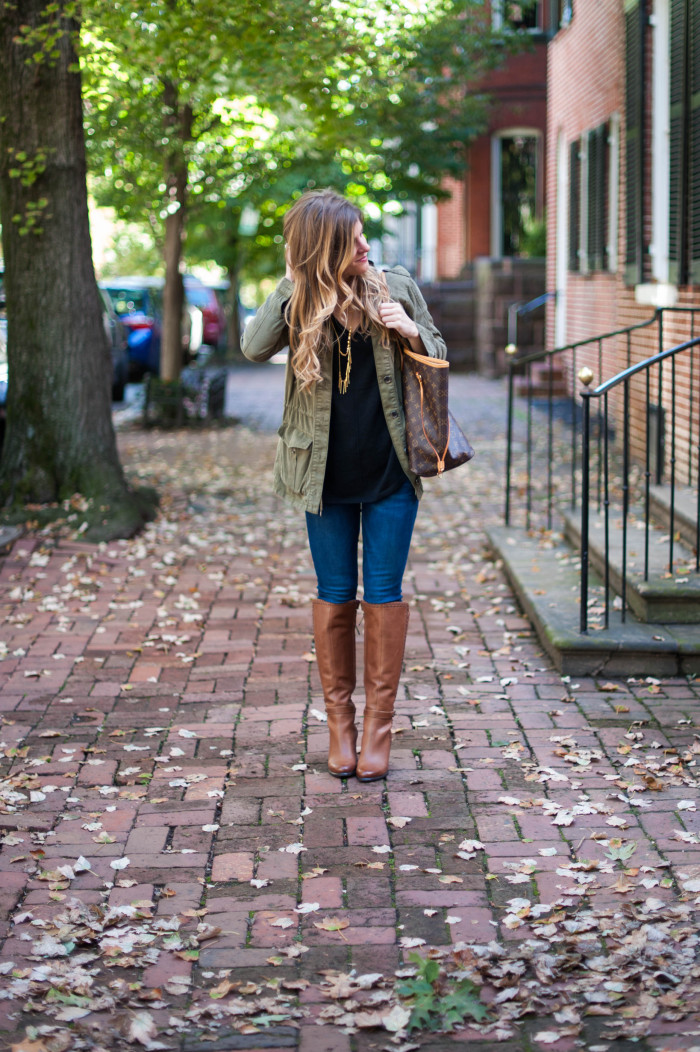 black sweater and brown boots with utility jacket and jeans