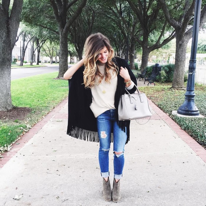 casual outfit with neutral sweater, distressed denim, and oversized fringe hem cardigan