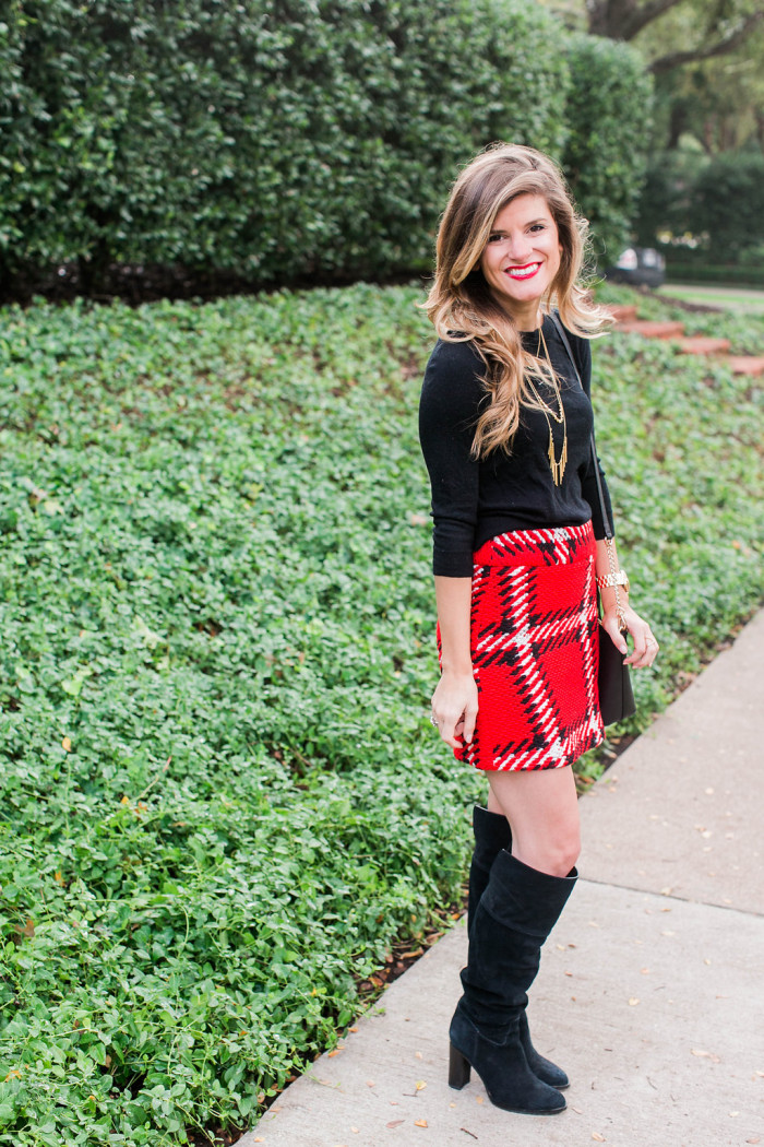 Red black plaid mini skirt with black tall boots, black sweater, gold necklace, kate spade crossbody holiday outfit 