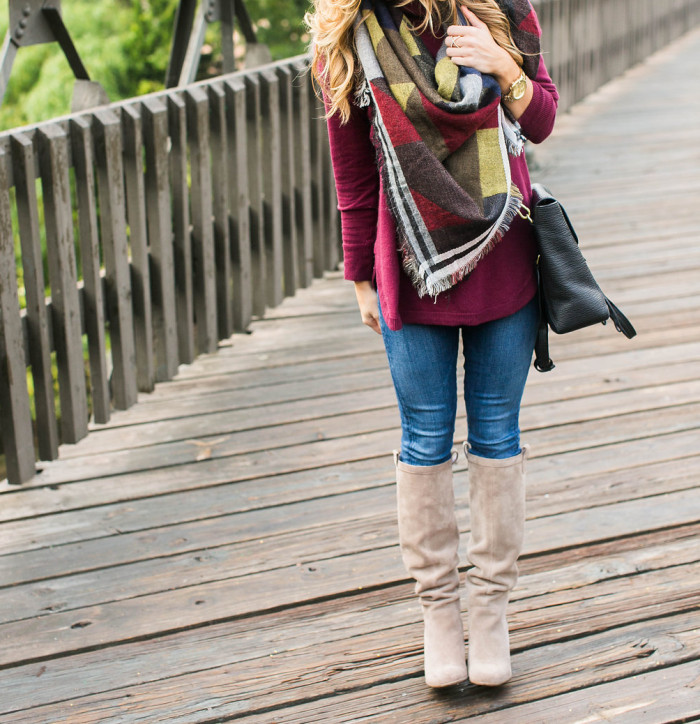 fall outfit with color block blanket scarf, burgundy turtleneck, tall boots, jeans