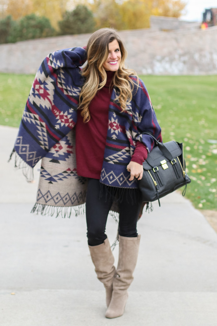 fall outfit with fringe poncho with burgundy turtleneck sweater and tall boots