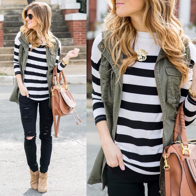 brighton the day wearing striped sweater and utility vest with distressed jeans 