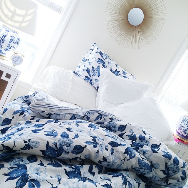 brighton the day bedroom with blue and white bedding and gold sunburst over bed