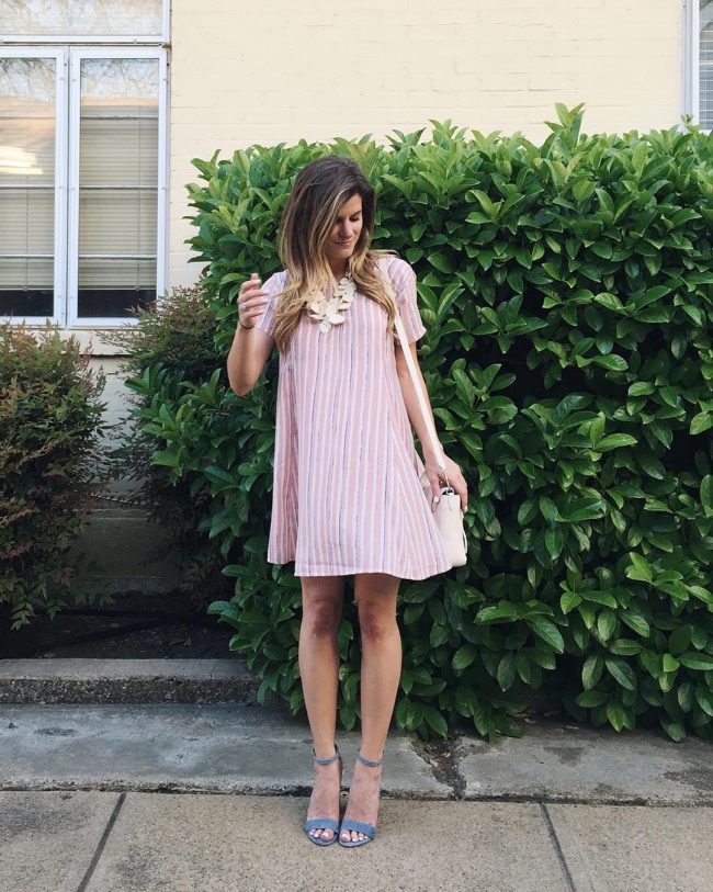 @brightonkeller wearing fit and flare swing dress in blush pink with baby blue heels and a statement necklace