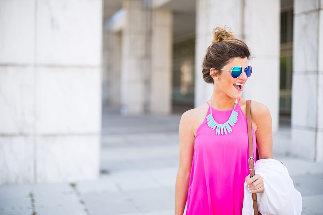 Brighton the day wearing pink dress with turquoise statement necklace