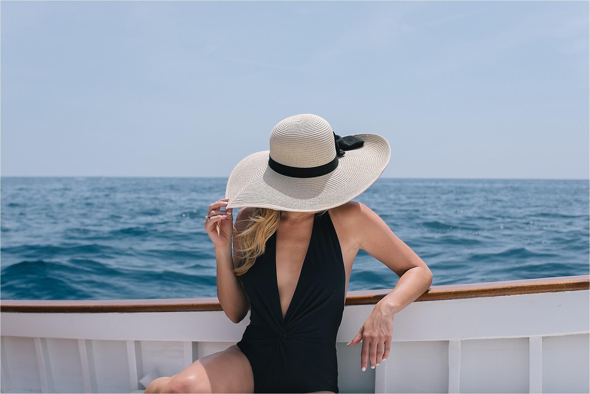brighton keller wearing black plunge front one piece on private boat tour in capri island italy