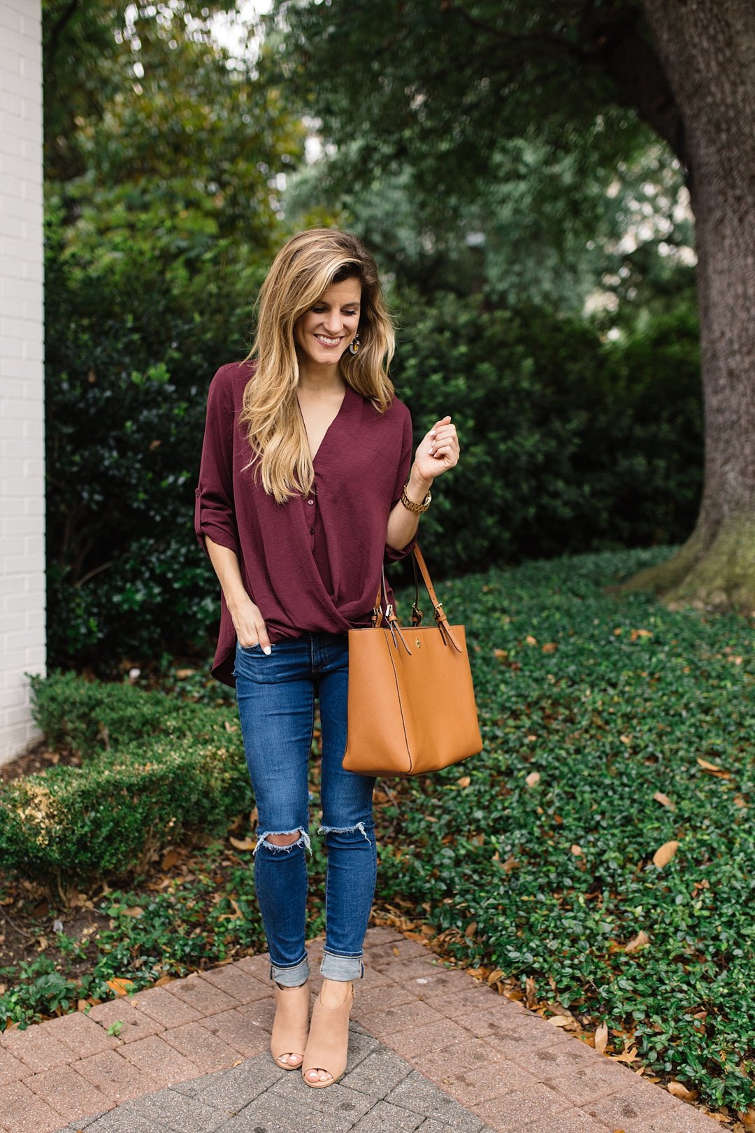transitional summer to fall cute outfit idea with burgundy blouse, distressed denim and peep toe booties