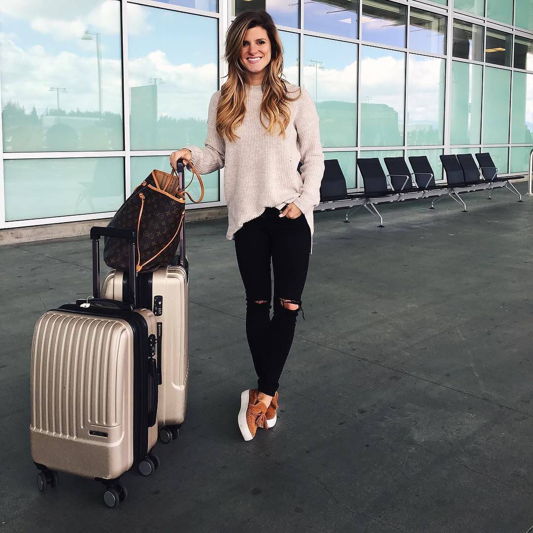 brighton the day travel outfit with distressed black jeans and brown sweater