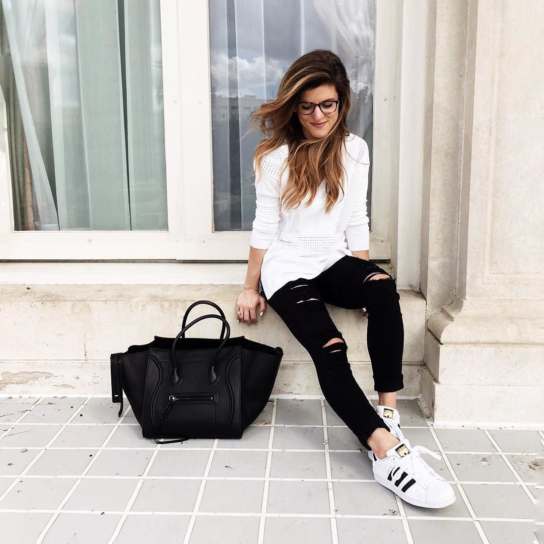 brighton keller and white sweater and black distressed jeans with superstar sneakers