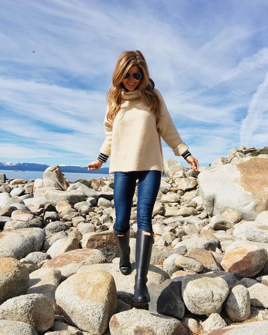 lake tahoe outfit exploring rocks, hunter boots, jeans, sweater