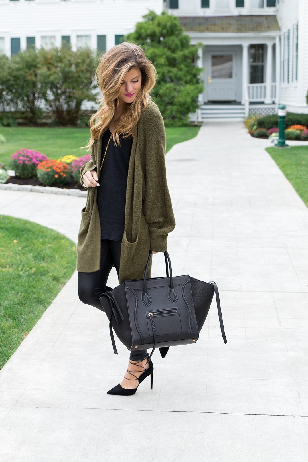 all black outfit idea, wearing all black with a long olive cardigan, liquid leather leggings winter outfit, black on black outfit, going out winter outfit, winter date night outfit, celine phantom tote, sam edelman strappy heels, winter all black outfit