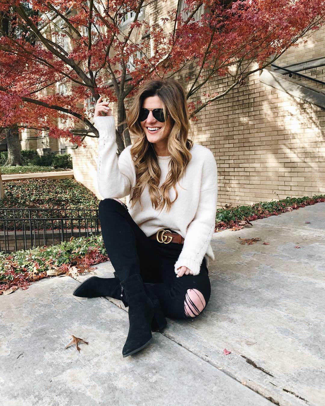 brighton the day styling black jeans, boots, oversized sweaters, and statement belt