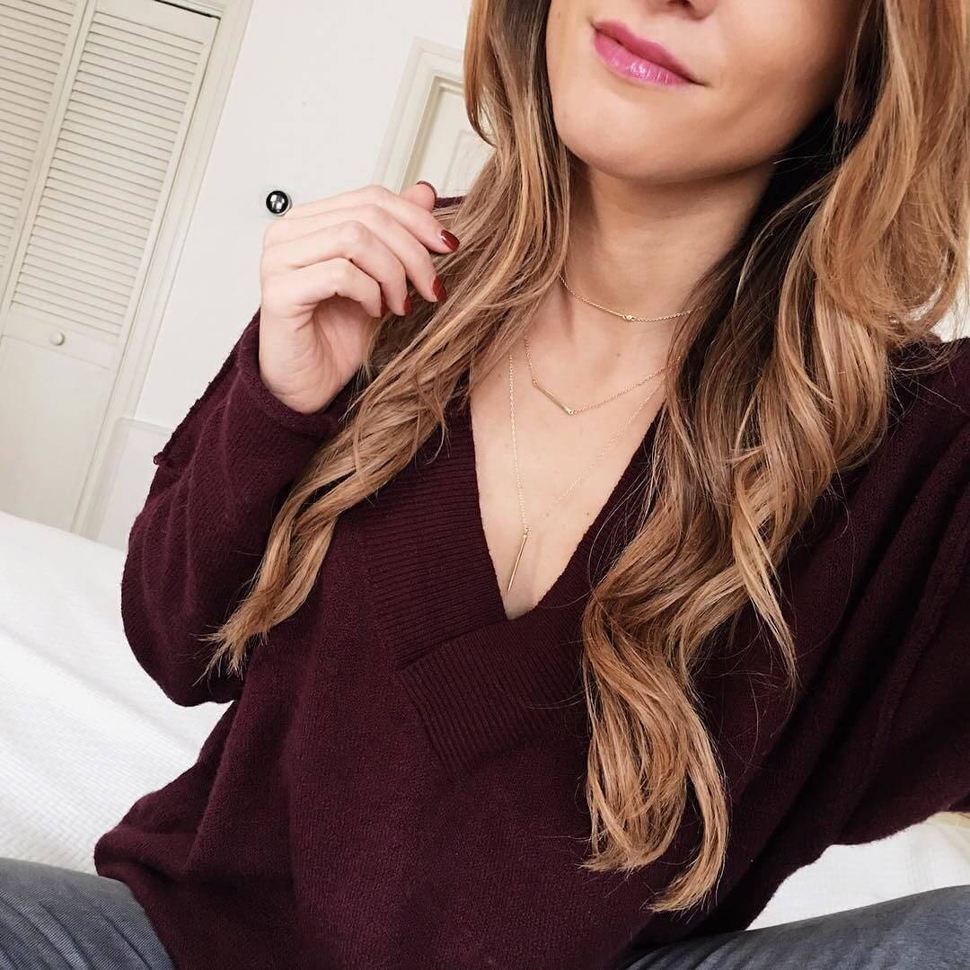 brighton keller wearing maroon sweater with layered delicate necklaces