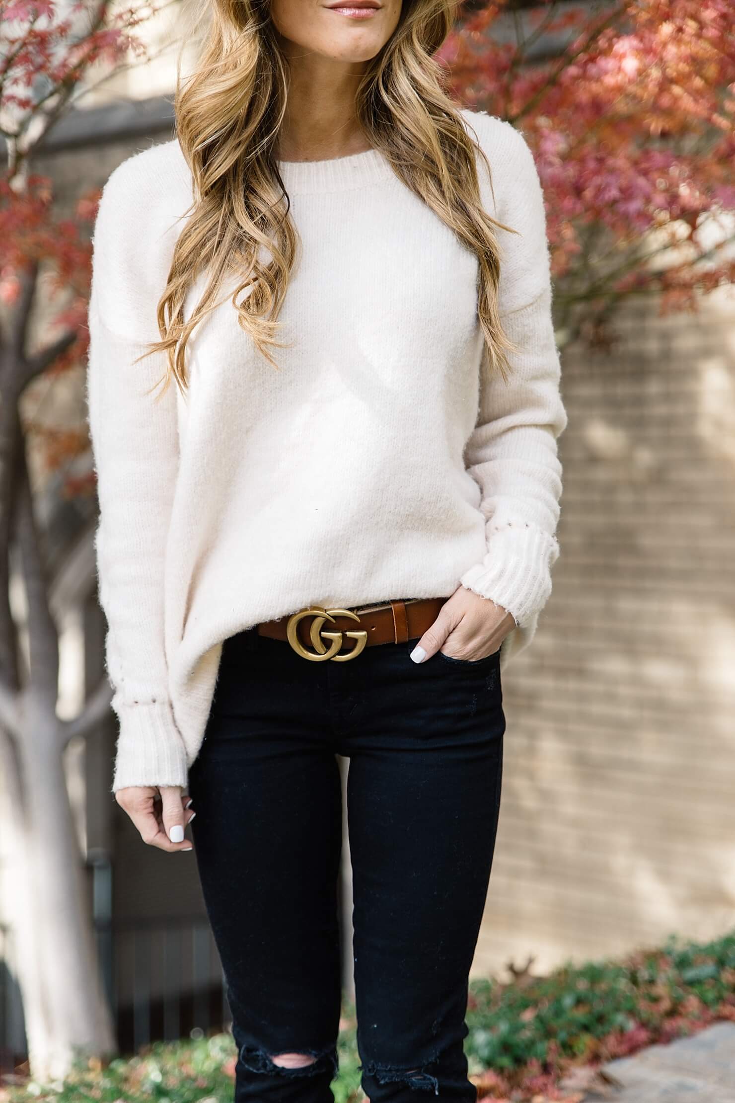 brown and gold gucci logo belt, oversized cream sweater, crew neck sweater with black jeans, front tuck and oversized sweater