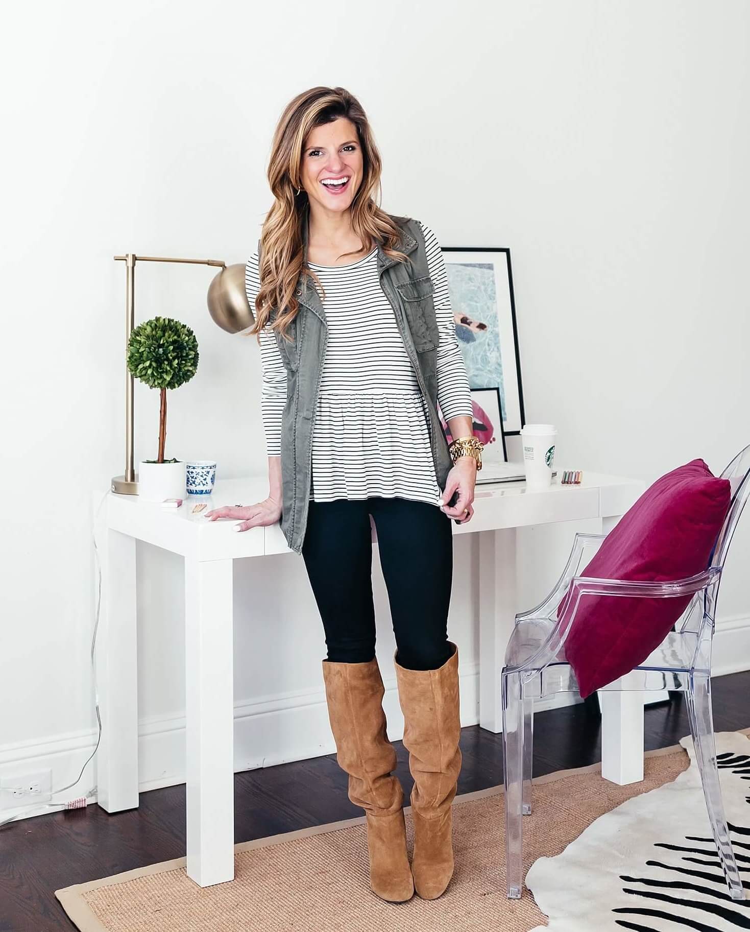 striped long sleeve tee with black jeans and brown boots with utility vest 
