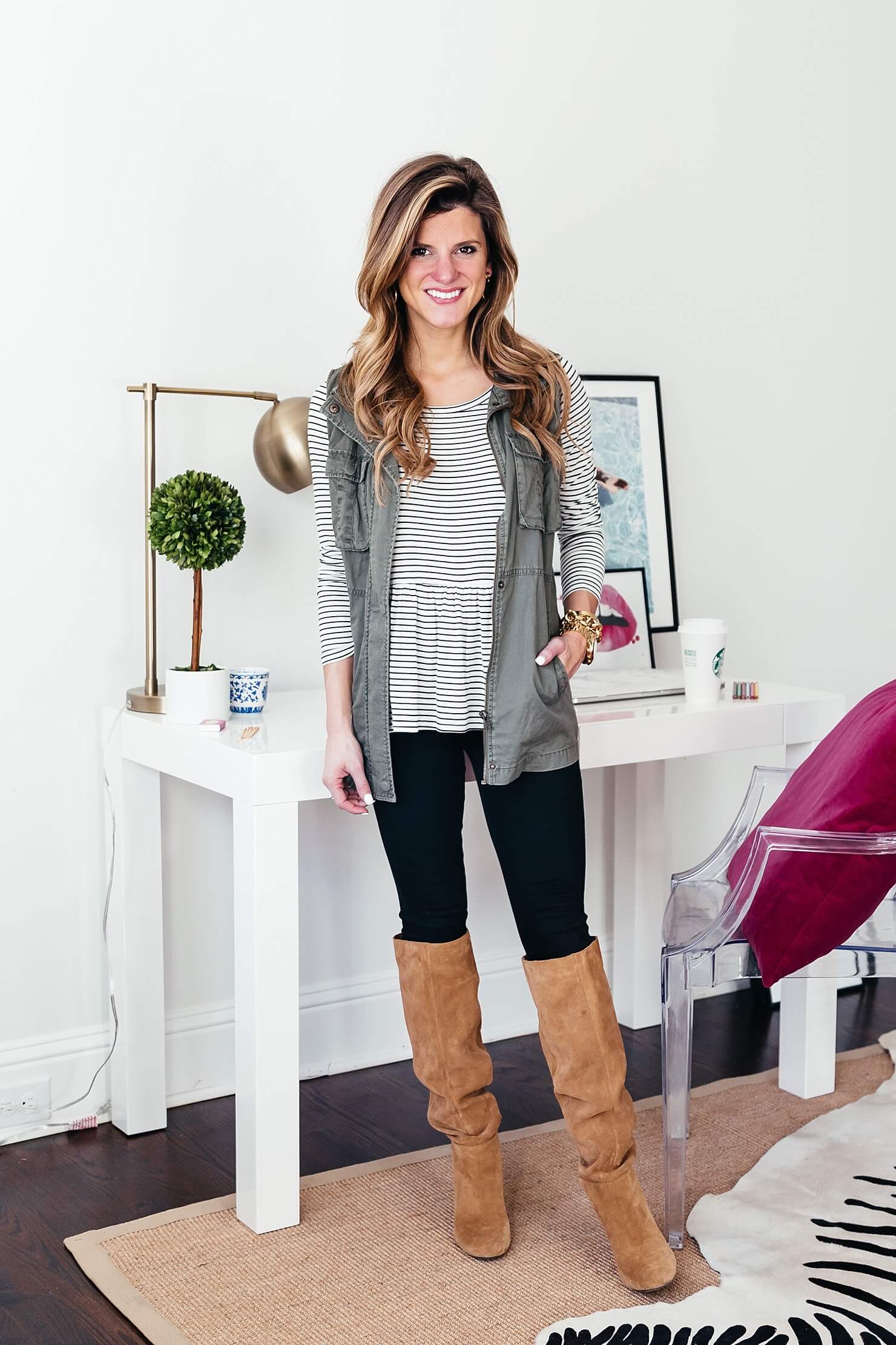 striped long sleeve tee with black jeans and brown boots with utility vest 