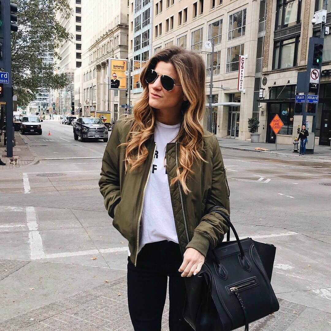 green bomber jacket and graphic tee with black jeans 
