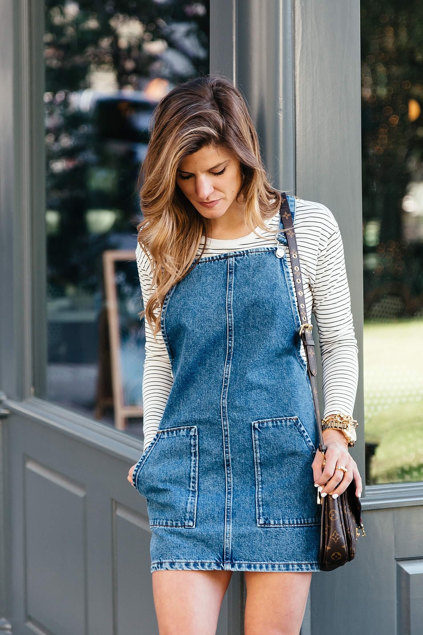 denim dress with sneakers and long sleeve striped tee