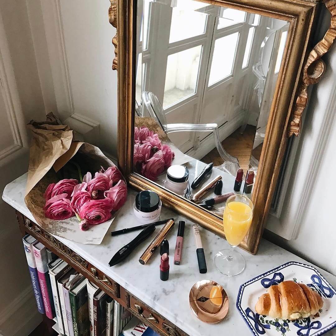 Parisian morning makeup, orange juice, french style gold mirror, paris inspiration, paris inspo, makeup setup with flowers and oj