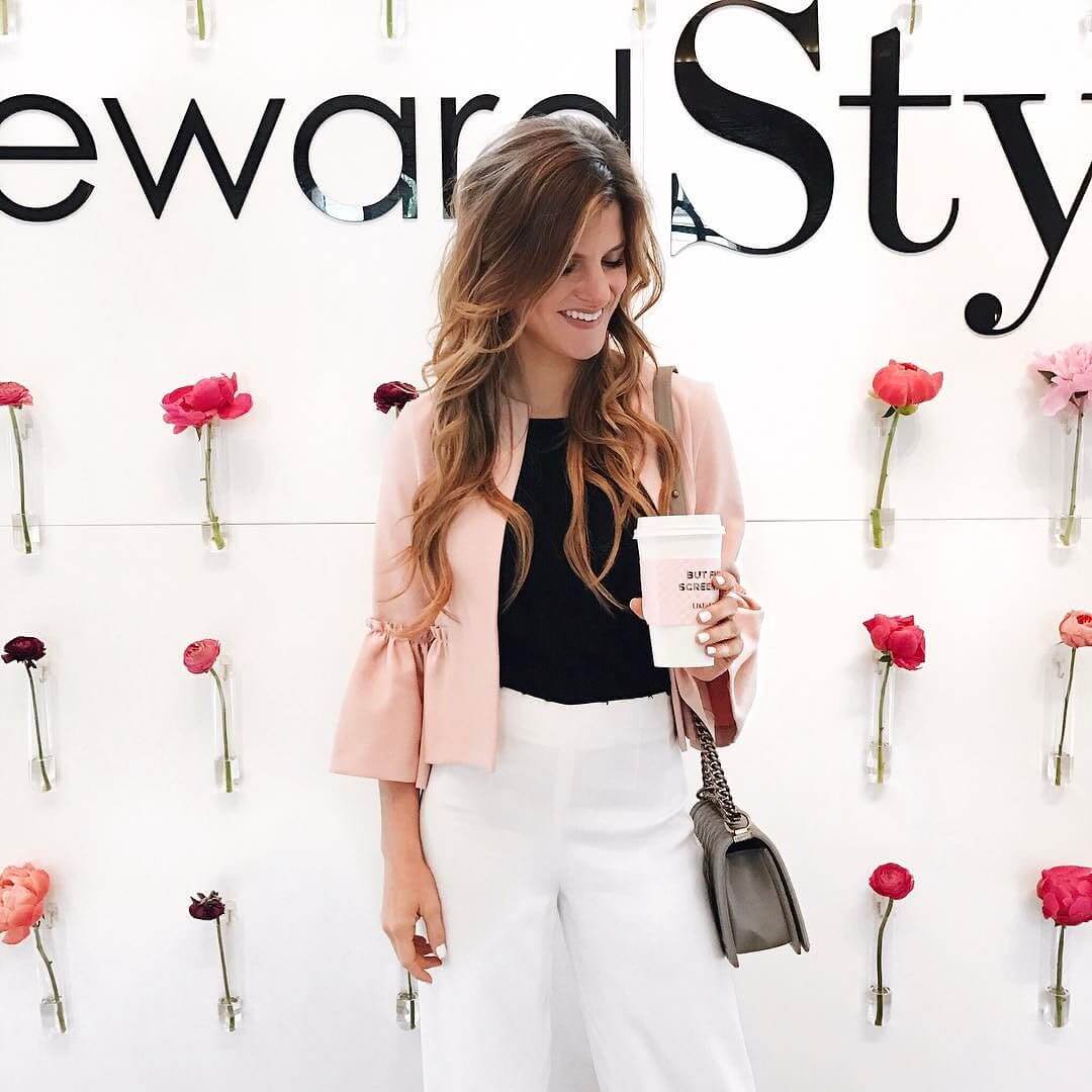 RewardStyle conference wearing black sweater, pink jacket and white pants, business casual 