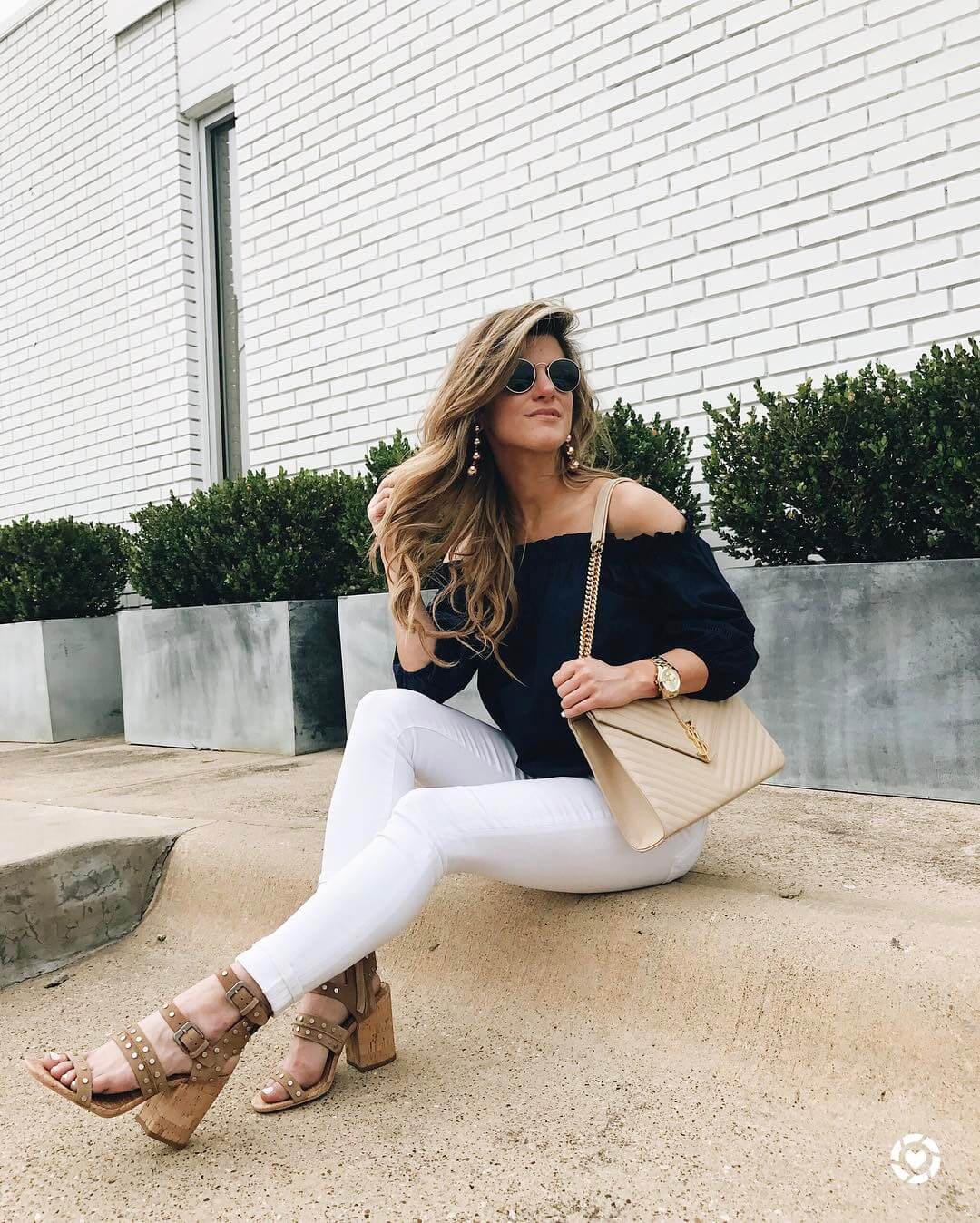 brighton keller wearing ots blue top with white jeans and neutral sandals 