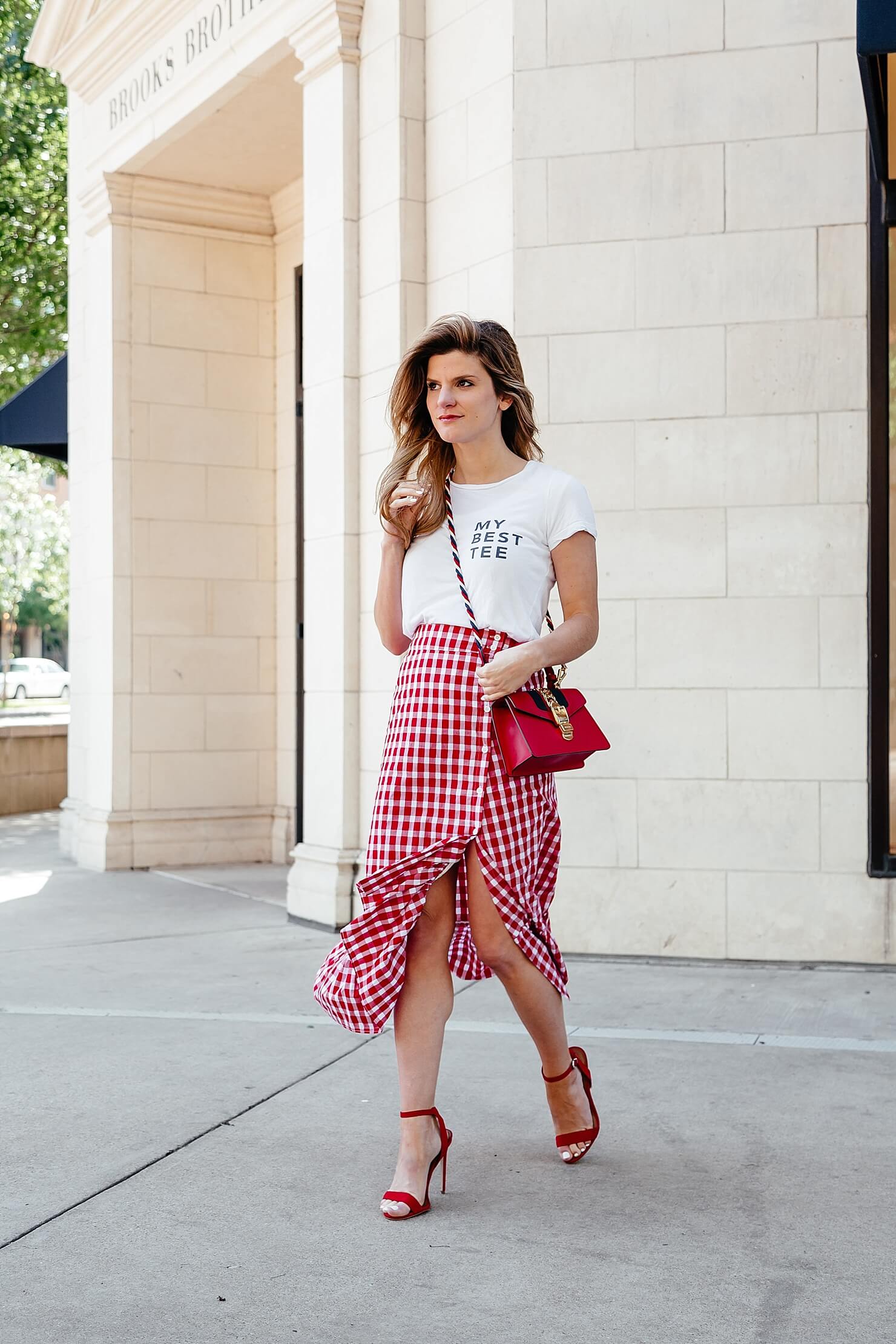 graphic white tee with gingham skirt and red accessories