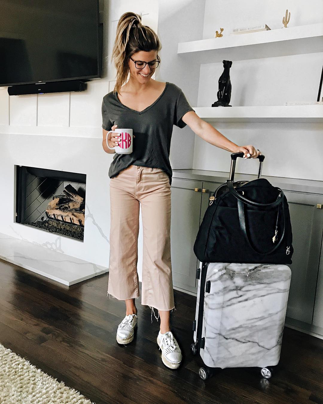 travel outfit wearing pink cropped jeans with grey tee and platform sneakers 
