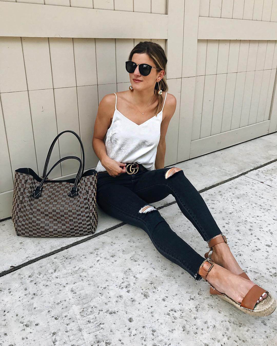 brighton keller wearing white tank with black distressed jeans and espadrilles with moreau bag