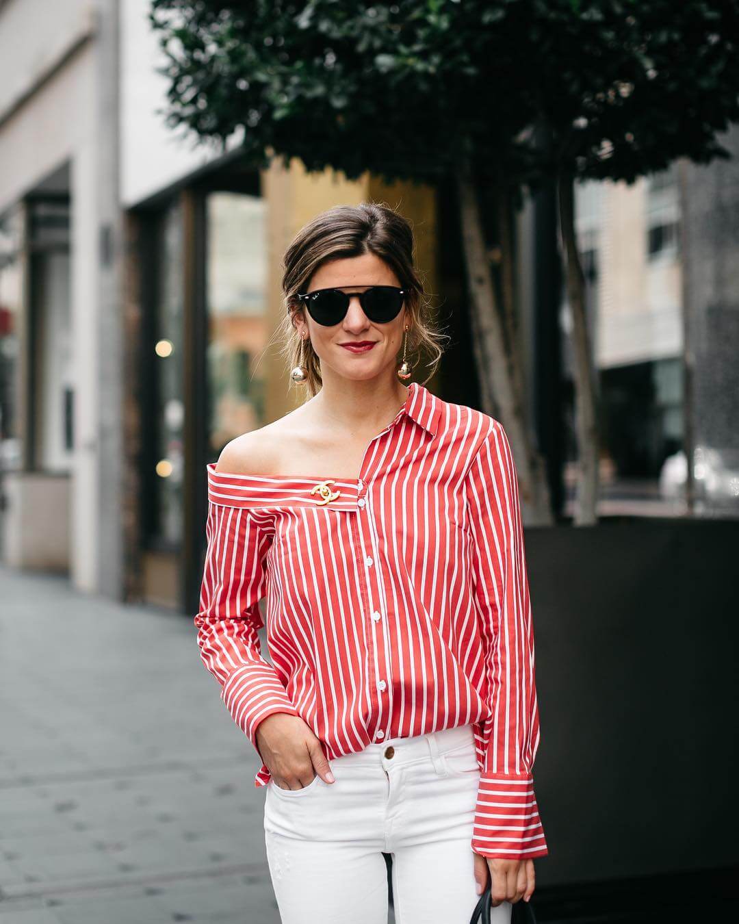 brighton keller wearing one shoulder button down with chanel pin