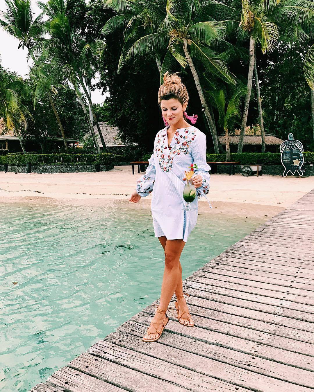 brighton keller on the boardwalk wearing embroidered dress, lace up sandals, and tassel drop earrings