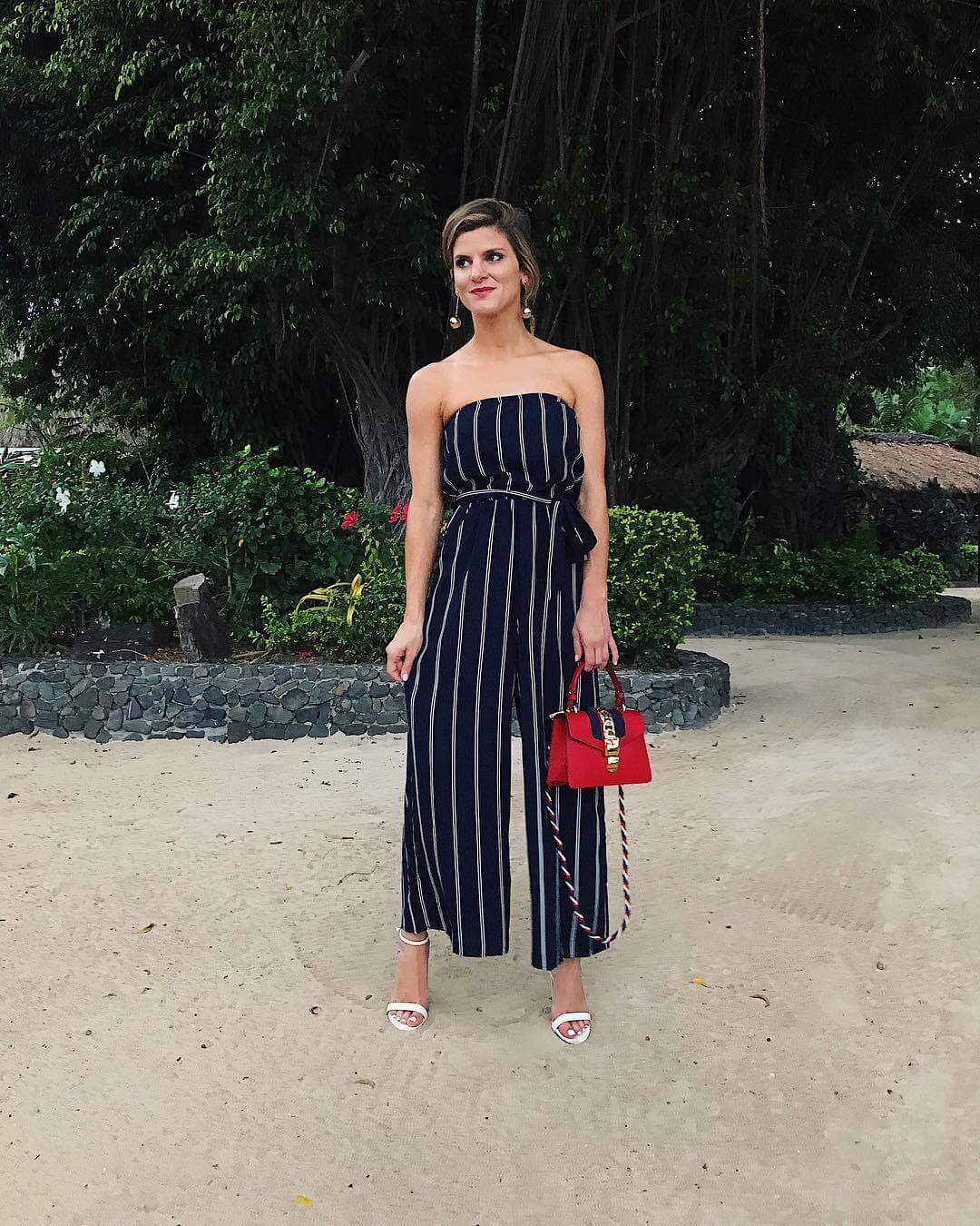 brighton keller wearing striped strapless jumpsuit with white sandals