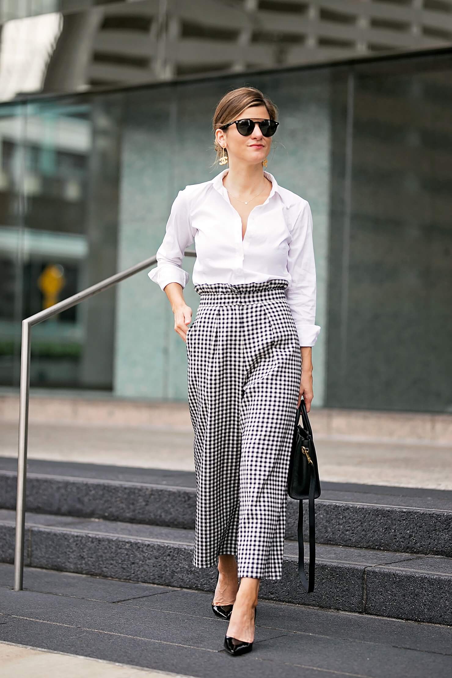 brighton keller wearing gingham pants with white button down and black pointy toe pumps 