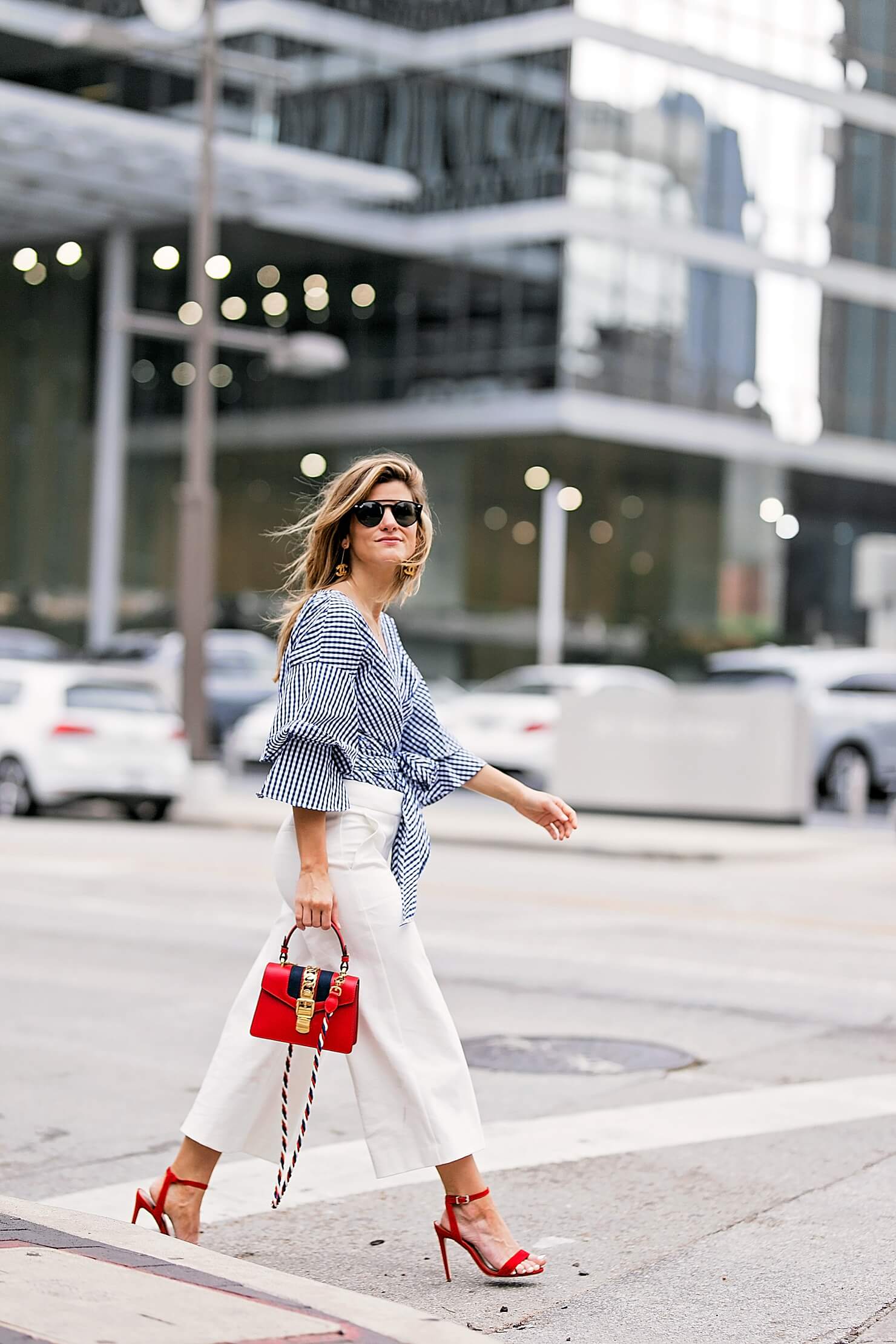 flared white pants with gingham wrap top, red heels and red bag
