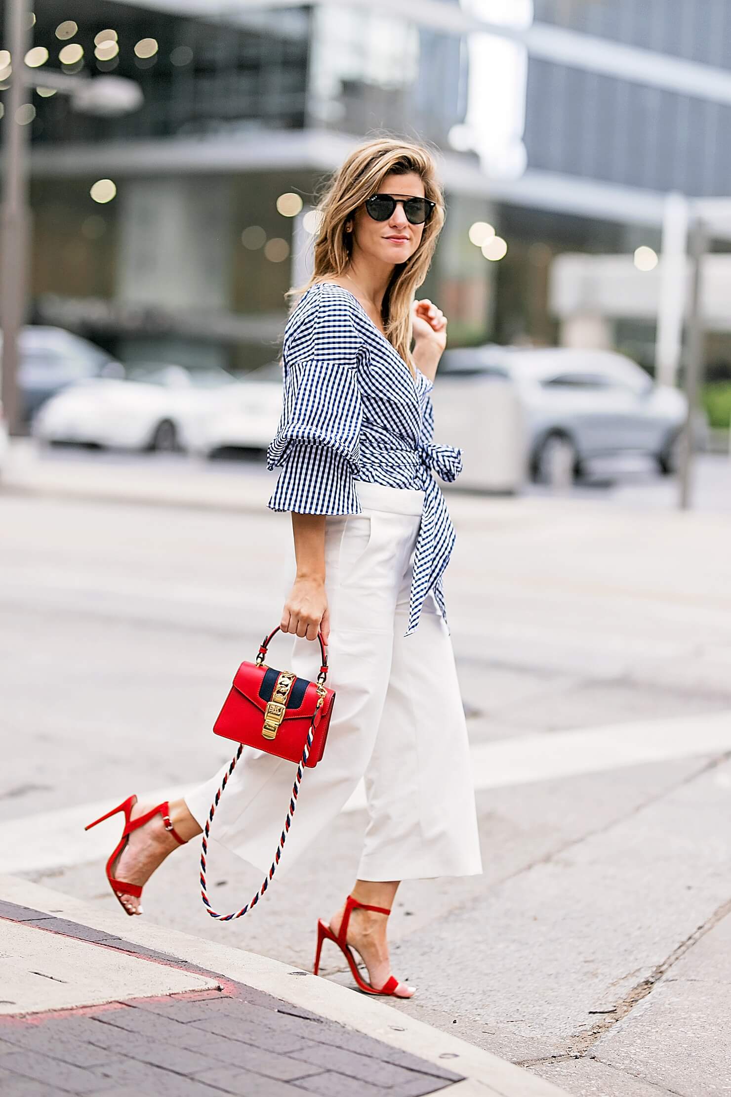 flared white pants with gingham wrap top, red heels and red bag, workwear