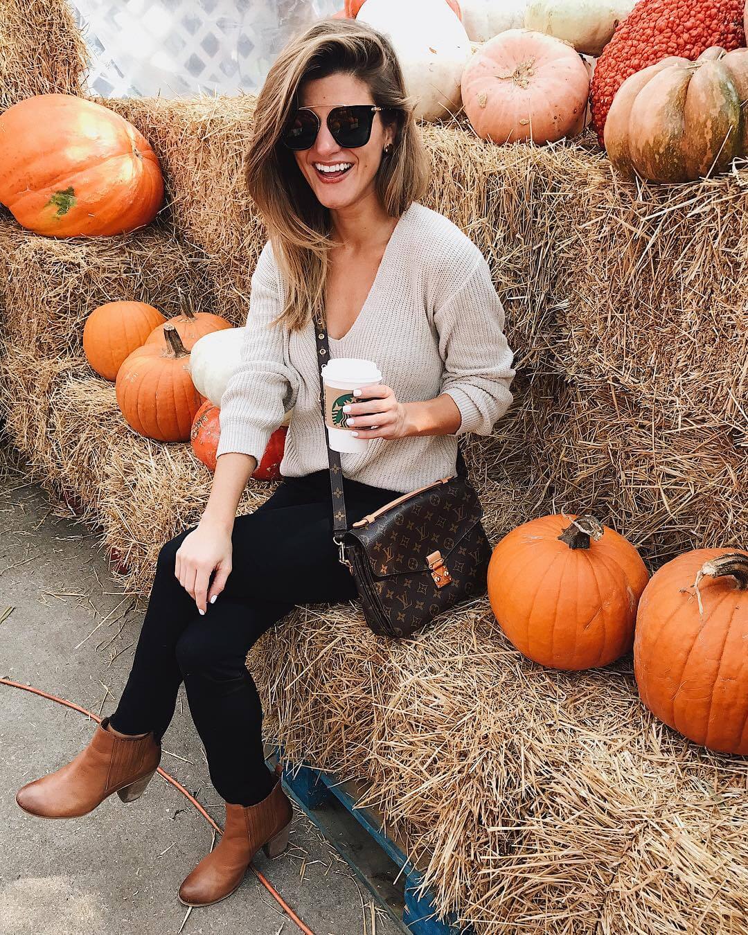 cream cardigan with black jeans and brown booties while pumpkin picking 
