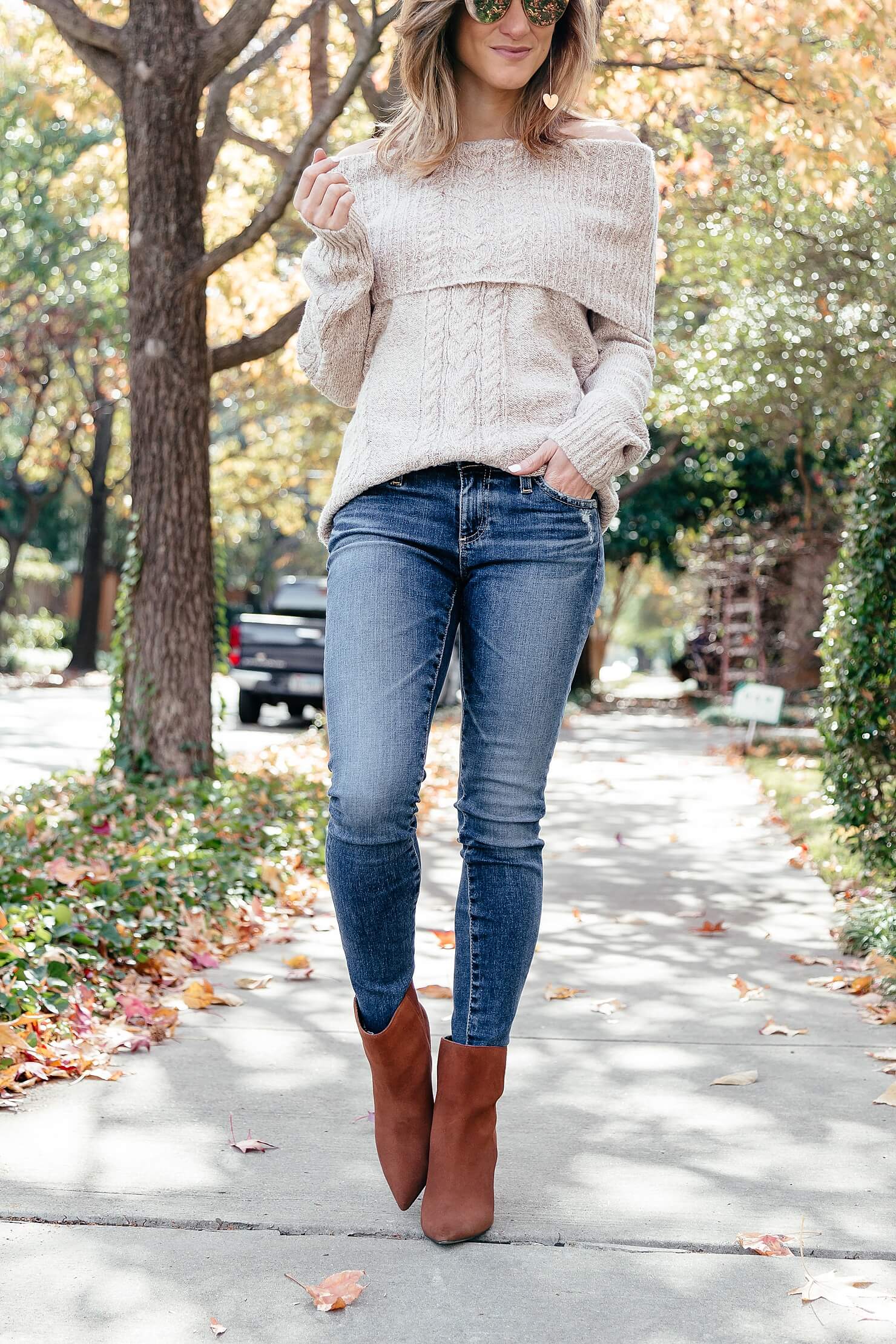 off the shoulder cable knit sweater, ag jeans, and brown heel booties