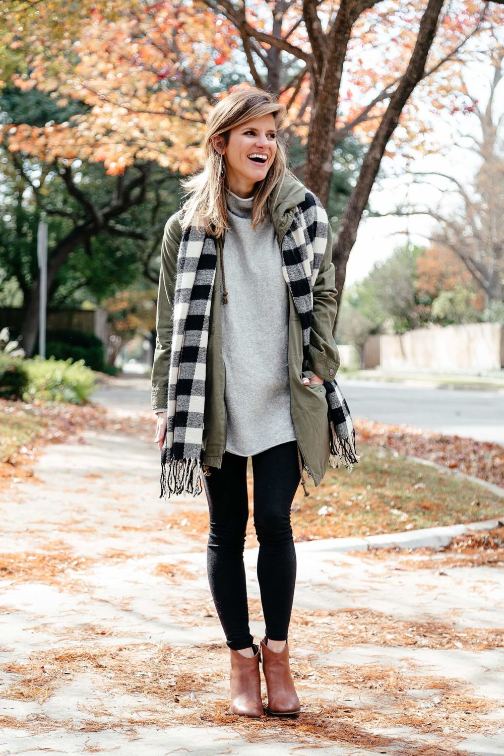 tunic sweater with leggings and brown booties paired with green utility jacket and buffalo check scarf