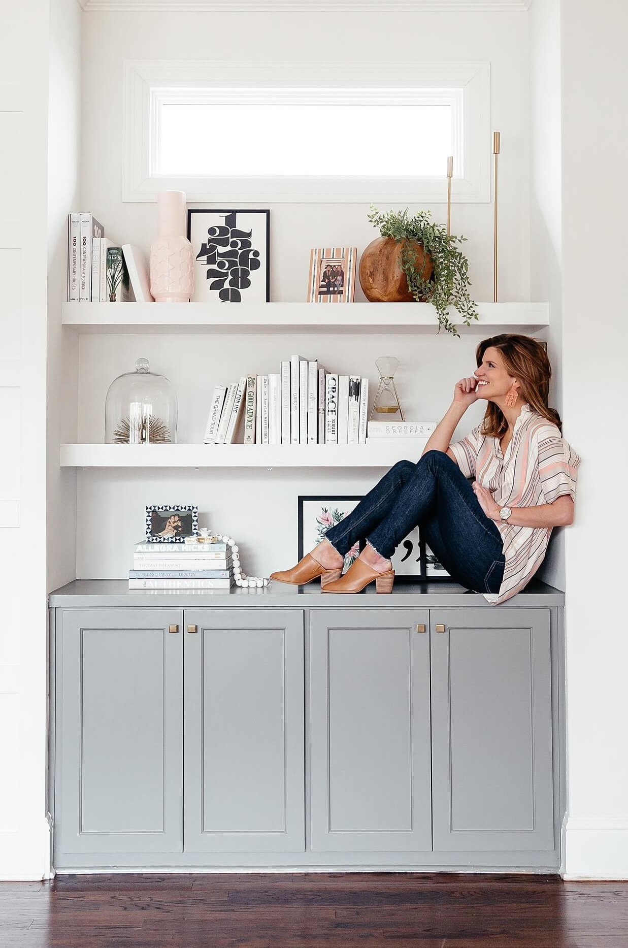 brighton keller sitting on living room bookshelves, Sherwin Williams Chelsea Grey Paint color on cabinets