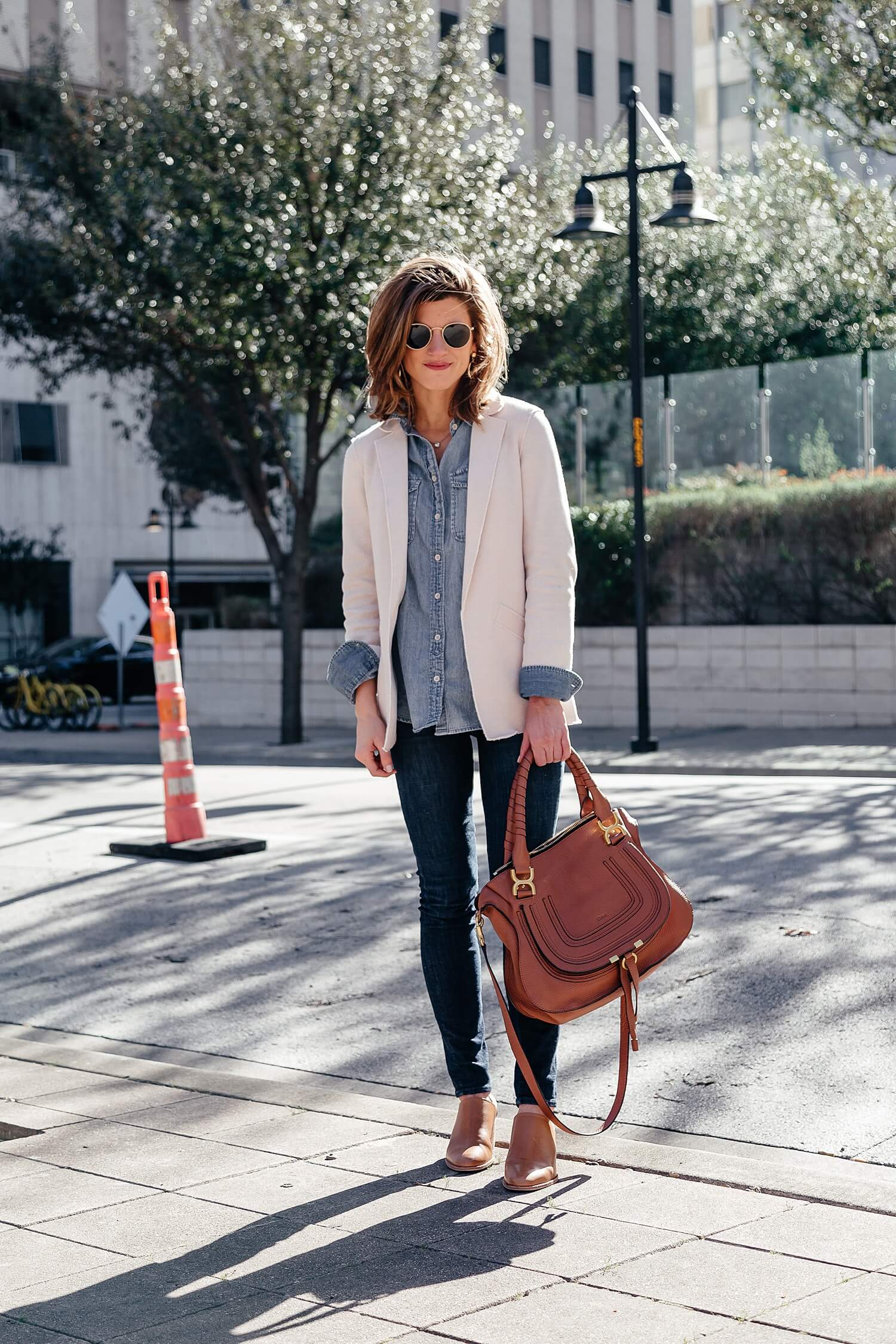 brighton keller wearing dark jeans with chambray shirt and cream blazer, canadian tuxedo casual spring outfit