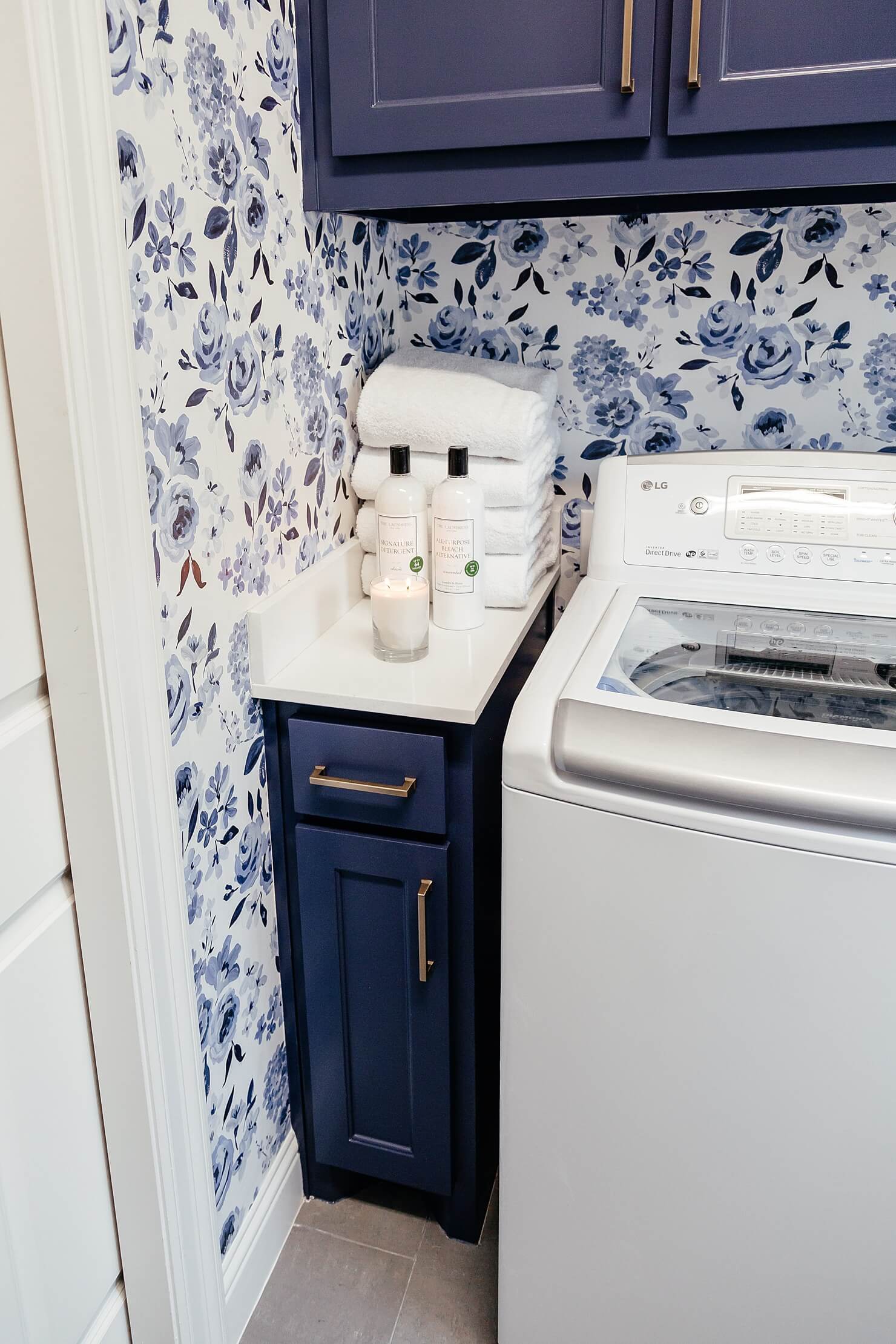 brighton keller laundry room blue and white print wall paper navy blue painted cabinets cute laundry room