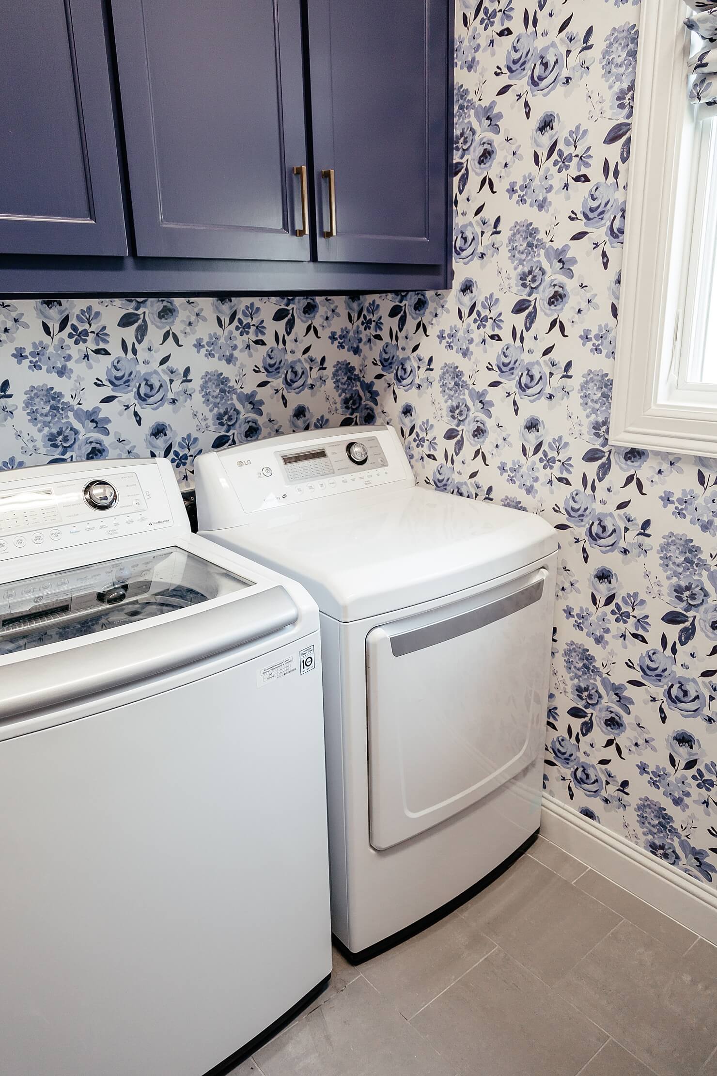 brighton keller laundry room blue and white print wall paper navy blue painted cabinets cute laundry room