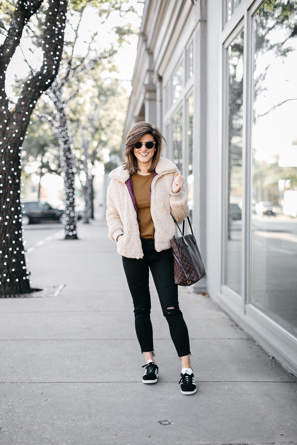 cream tan teddy jacket with black jeans and sneakers