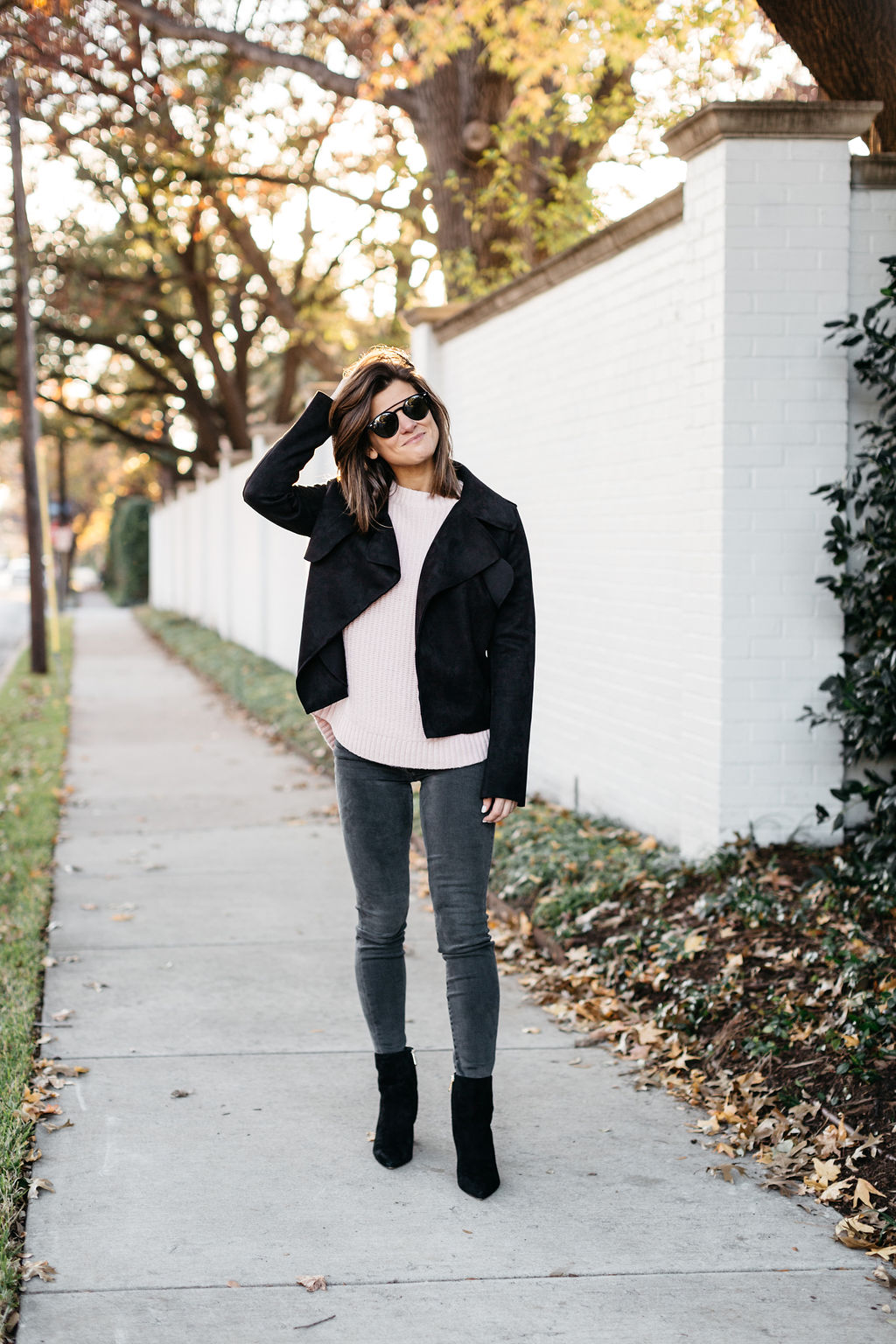 grey jeans pink sweater black moto jacket and black booties 
